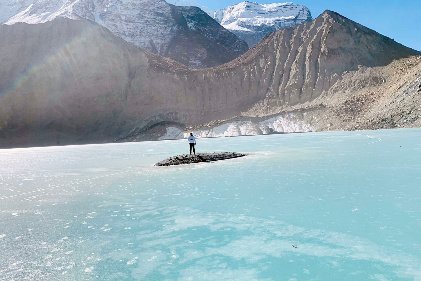 पञ्चकुण्ड तालमा जमेको पानीमाथि रमाउँदै पर्यटक